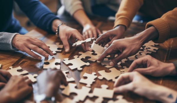 Mitarbeiter konzentrieren sich auf das Zusammensetzen eines Puzzles als Teambuilding-Maßnahmen